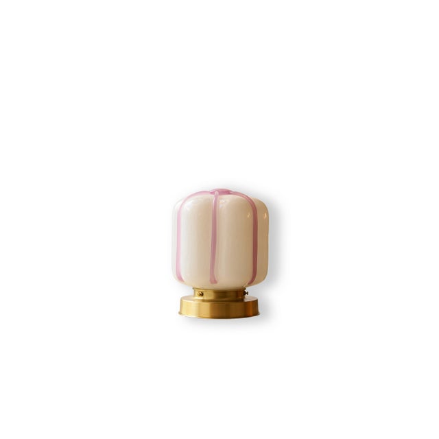 A compact wall or ceiling light defined by a soft, rounded silhouette and distinctive hand-shaped glass. The opaline...