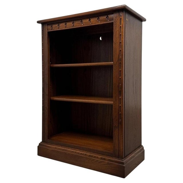 A beautifully proportioned 20th-century oak open bookcase by Ercol, combining understated British design, practical open...