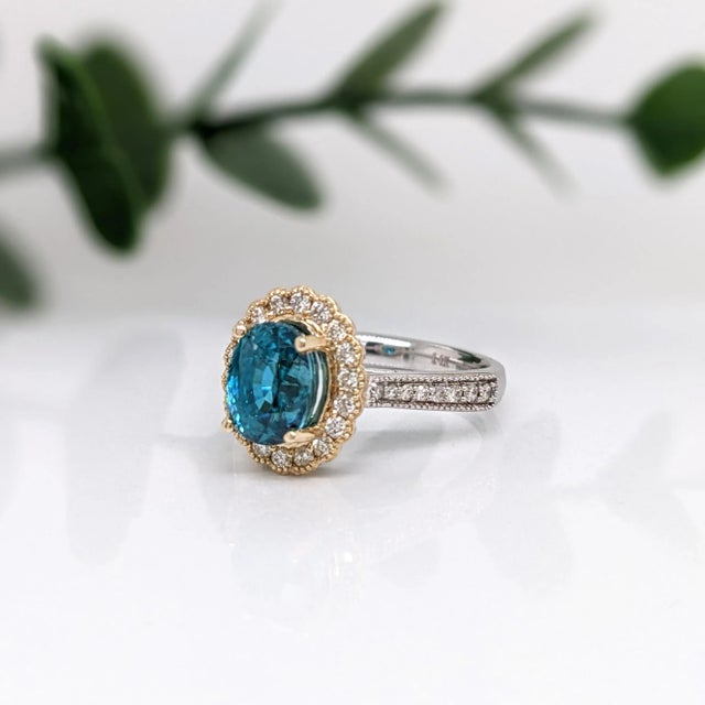 This elegant ring features a 4.15ct gorgeous sparkling Blue Zircon in 14K solid gold with natural earth mined diamonds and...