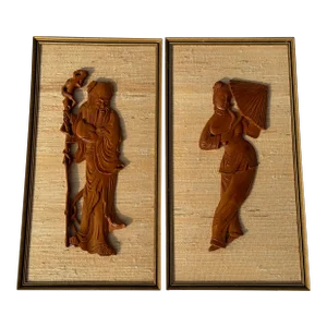 Mid Century Pair of Asian Style Art Panels Featuring Carved Teak Figures on Raffia Background