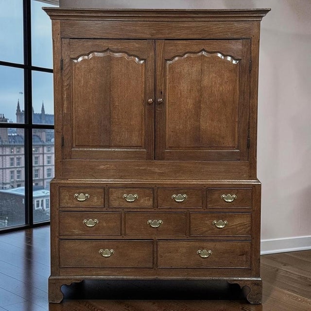 A beautifully proportioned late 18th century English Georgian oak linen press cupboard on chest, offering an exceptional...