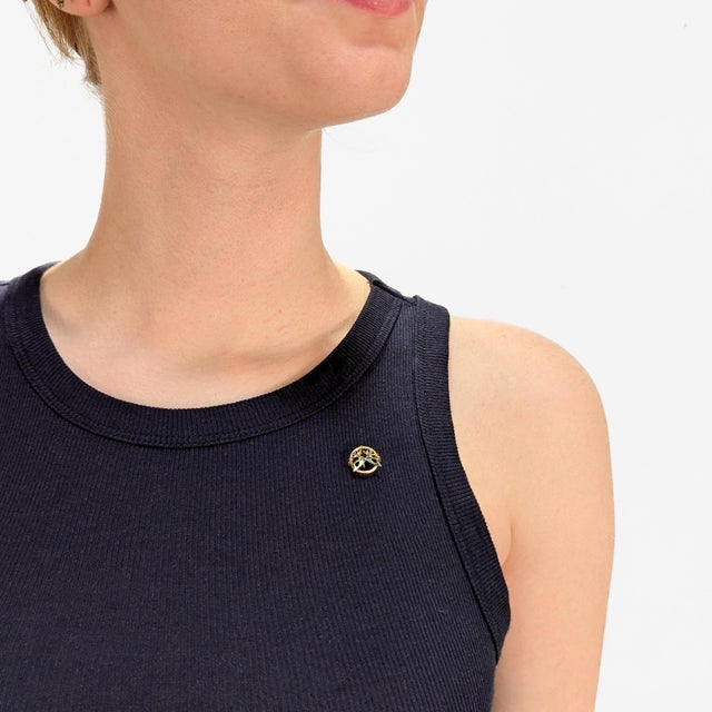 A fine antique two-tone gold stickpin. In 18 karat yellow & white golds. The head of the pin with 2 interlocked white gold...