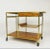 A stunning Paul McCobb bar or serving cart for Calvin with a brass frame, travertine top, and refinished mahogany shelves...