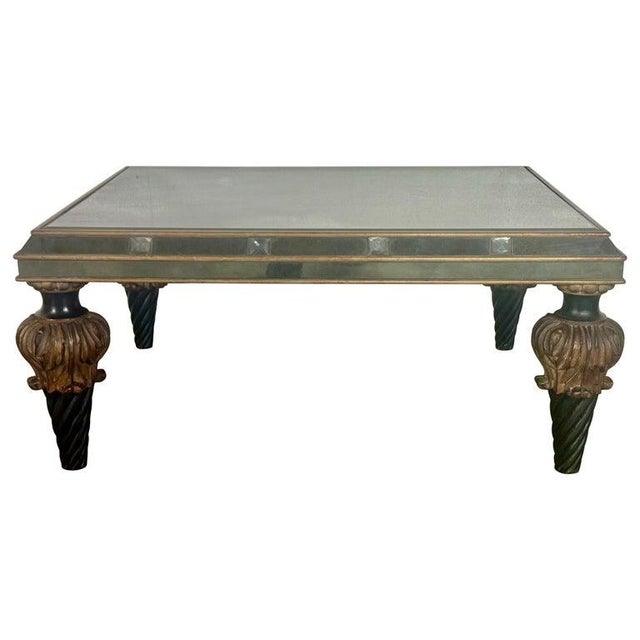 A striking Hollywood Regency–style coffee table featuring a fully mirrored top and apron, elevated on dramatic carved wood...