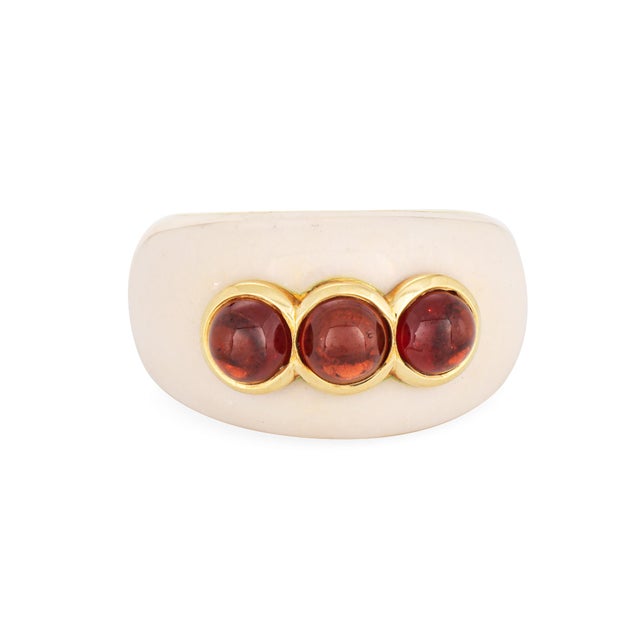 Stylish contemporary garnet and enamel dome cocktail ring crafted in 18 karat yellow gold. Three cabochon cut garnets each...