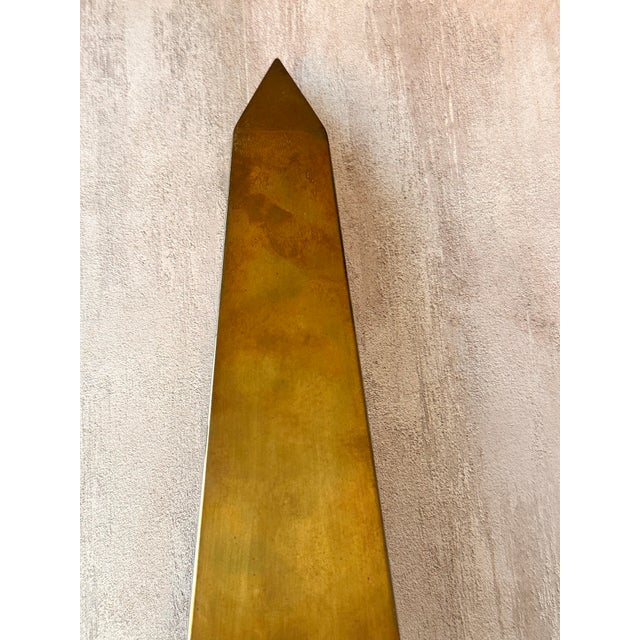 Tall tapered brass obelisk with raised ball accents and a stepped architectural base. The original Made in Hong Kong label...