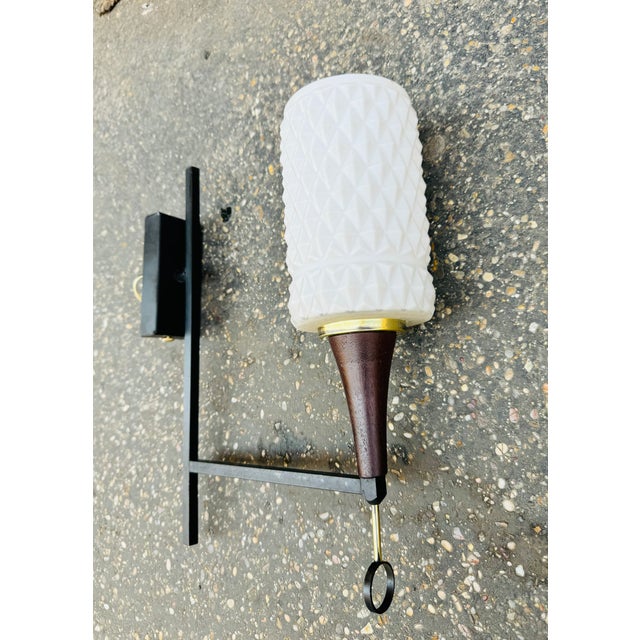 1960s wall light in matt black lacquered brass with shiny brass finishes, opaline glass, from a hotel. European Plug (up...