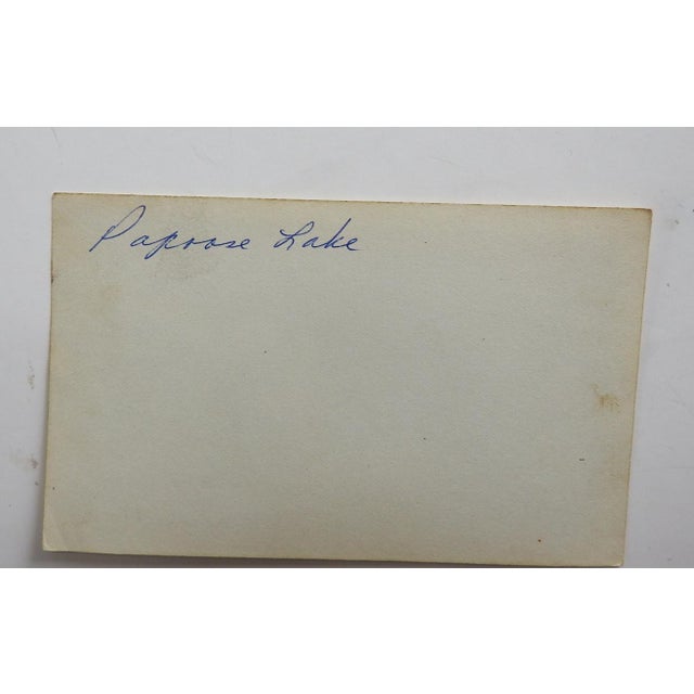 Early 20th century snapshot photograph of a group of men eating at a makeshift table in front of a large tent. Note on...