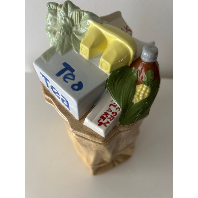 This is a vintage 1976 E.S. Molds ceramic canister designed to look like a brown grocery paper bag filled with food...