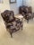 Beautiful pair of vintage upholstered armchairs featuring a rich dark floral tapestry fabric and carved wood detailed...