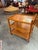 Constructed from richly grained teak with warm, glowing honey tones, the cart features a streamlined three-tier design...