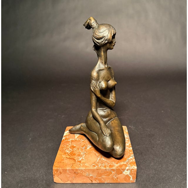 An elegant and expressive mid-century modern bronze sculpture by Italian artist Frido Graziani depicting a seated female...