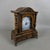 An original solid wood table clock with a built-in drawer and brass feral feet, attributed to 20th-century craftsmanship....