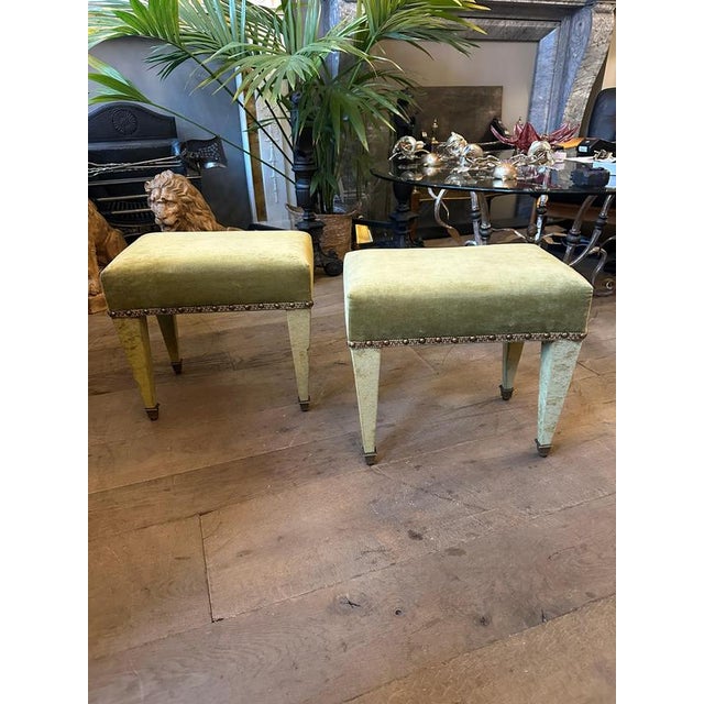 A very smart pair of green velvet footstools from the mid 20th century. Rectangular with tapering legs, brass sabots,...