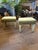 A very smart pair of green velvet footstools from the mid 20th century. Rectangular with tapering legs, brass sabots,...