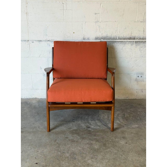 Featuring sculpted paddle armrests and a vertical spindle back frame, this lounge chair offers refined architectural...