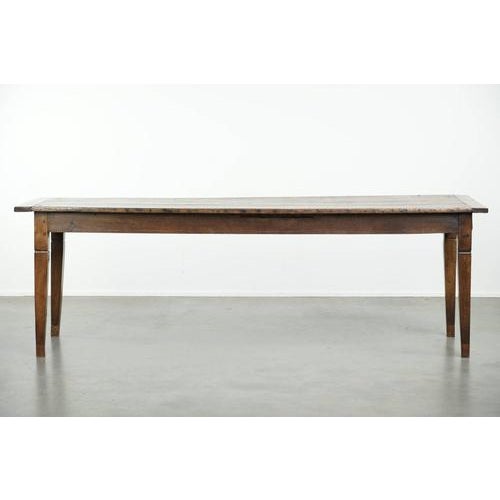 This antique oak dining table dates from the early 19th century and features a walnut top with an oak frame. The table has...