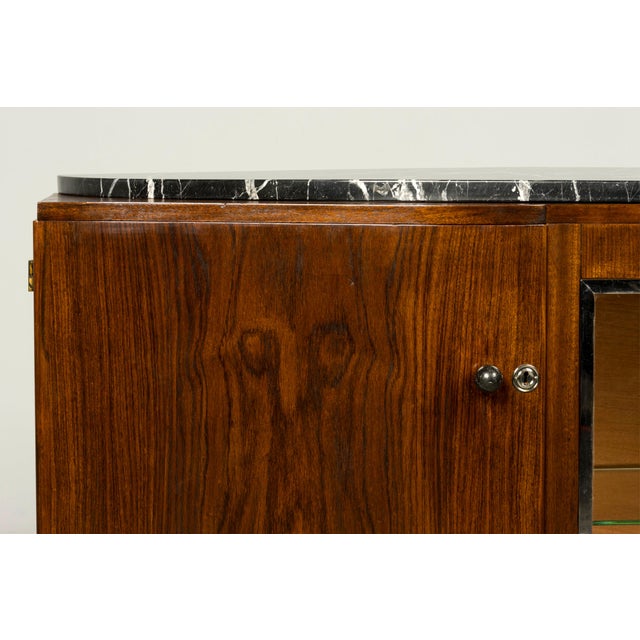 1930s French Art Deco walnut sideboard, sourced in Provence, France. The piece features a broad, gently shaped façade with...