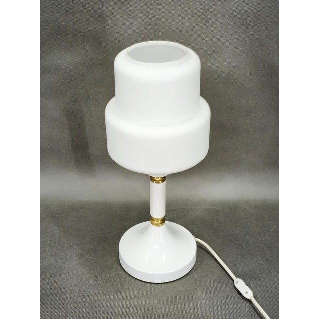 A distinctive 1970s table lamp by drukov, czechoslovakia, characterized by its sculptural geometric form and elegant...