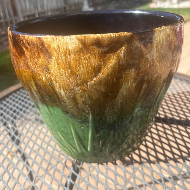 This RRP Company Jardinere has an incised Sun and Moon design that is Green on the bottom and Brown on the top. This dates...