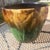 This RRP Company Jardinere has an incised Sun and Moon design that is Green on the bottom and Brown on the top. This dates...