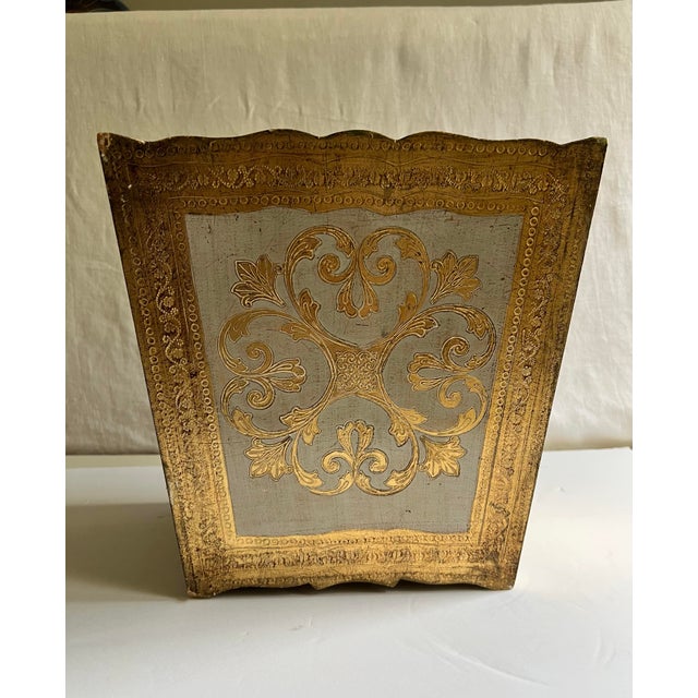 Italian Florentine waste basket with hand-applied gold gilt and soft ivory paint. Scalloped edges, floral reliefs, and a...