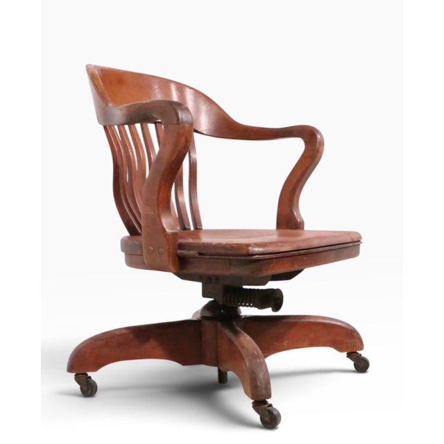 Classic antique swivel, tilt, Bank of England, Jury style desk chair. The chair features a continuous arm, back rest,...