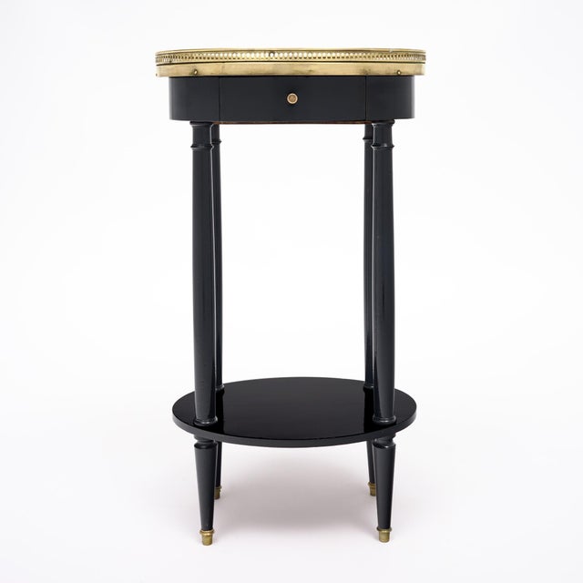 Side table from France in the Louis XVI style. This piece is made of solid wood construction, primarily mahogany. It has...