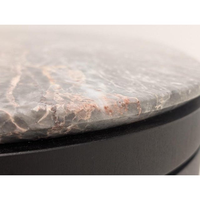 Premium sculptural coffee table with Quartzine stone top and stained fumed oak base. Features a distinctive rounded-square...