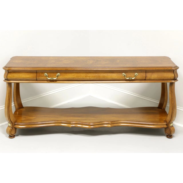 A Transitional style sofa table by Gordon's Furniture, of Johnson City, Tennessee, USA. Solid oak with burl oak top, brass...
