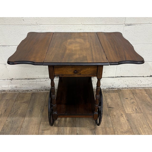 This is a beautiful vintage mahogany drop leaf bar cart or tea cart. It features a full sized bottom shelf, a cart handle,...
