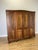 An elegant Vintage French Louis wardrobe crafted from Oak, featuring four panelled doors, decorative carved detailing, a...