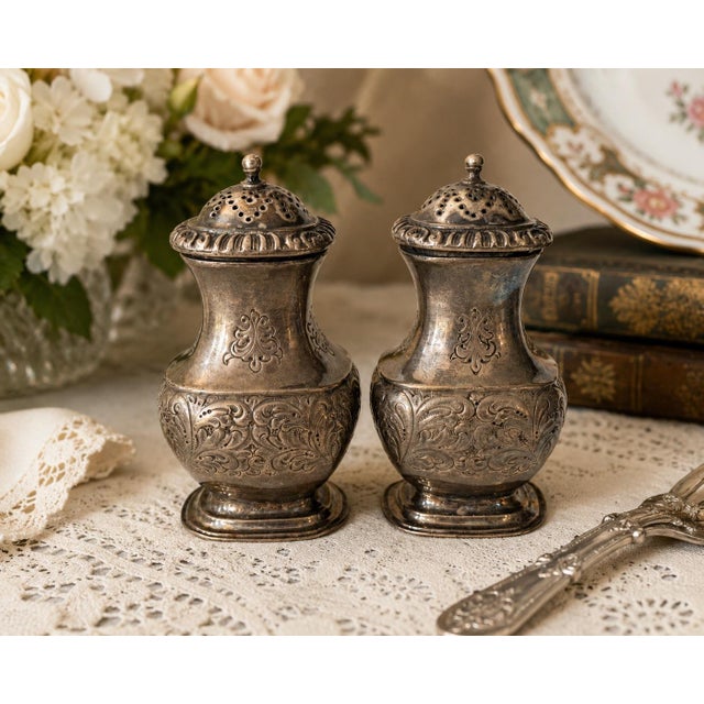 A charming pair of vintage English Barker Ellis silverplate salt and pepper shakers, distinguished by their richly...