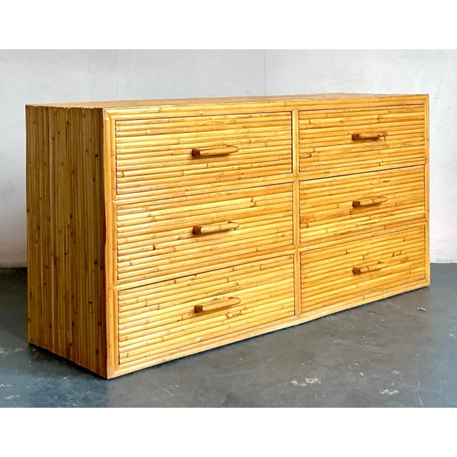 Presenting a charming vintage Boho Rattan Six-Drawer Dresser, an exceptional piece that beautifully marries the relaxed...
