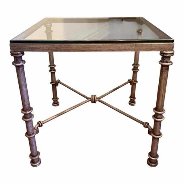 Vintage Giacometti style wrought iron side table in a brushed gray finish with thick glass top. The frame is detailed with...