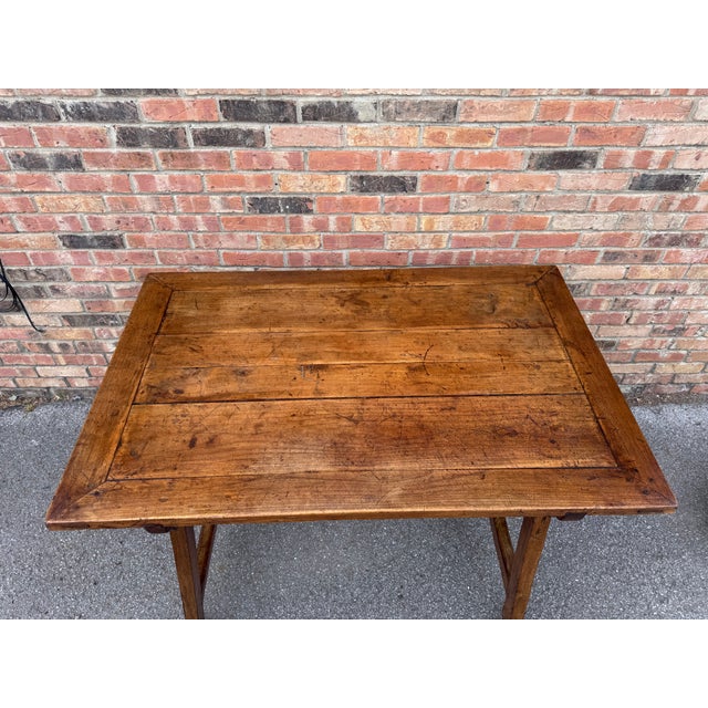 This is an amazing early 19th century French solid wood table with lovely details from the solid stretch bar legs accented...