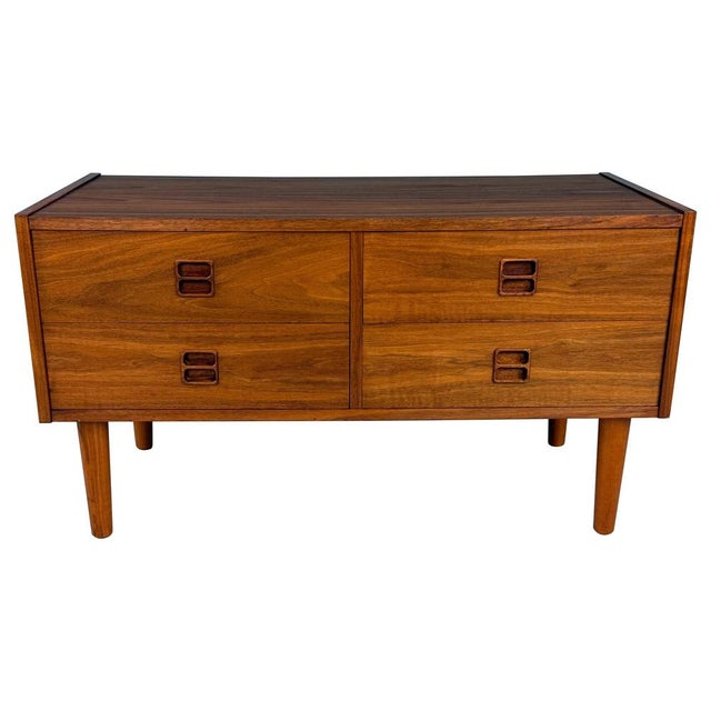 Elegant low chest of drawers from Denmark, designed in the 1960s. Made of dark teak and fitted with four long, spacious...