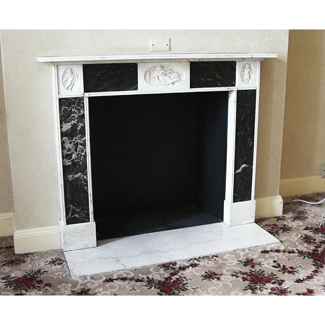 This English Regency style mantel is carved from statuary marble, and inlaid with black and gold Portoro marble. In the...