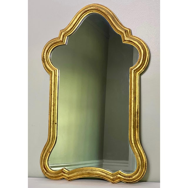 Gracefully curved Italian giltwood arched mirror, circa 1930-35. The shapely carved frame displays an excellent patina...