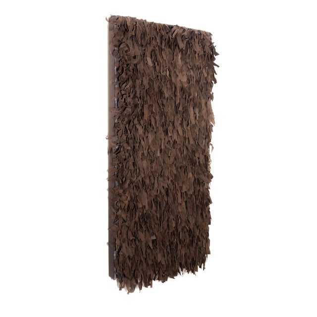 A 1950s sueded leather wall hanging made of coffee-brown strips in randomized lengths and widths. The strips are woven...