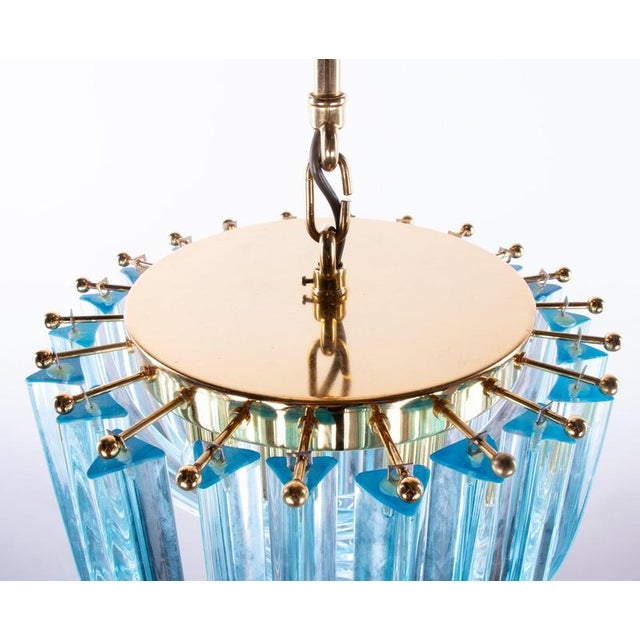 A breathtaking chandelier, handcrafted from aquamarine-colored, curved “triedri” murano glass and gold-plated brass....