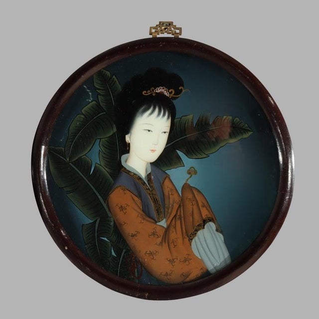 Presenting a pair of antique Chinese wall panels with portraits of a women reverse painted on glass and seated in an...