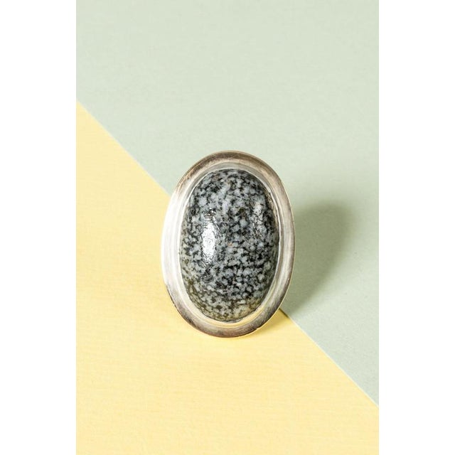 Silver silver ring by Anders Högberg, oversized with an oval cabochon cut granite stone. The silver around the stone is...
