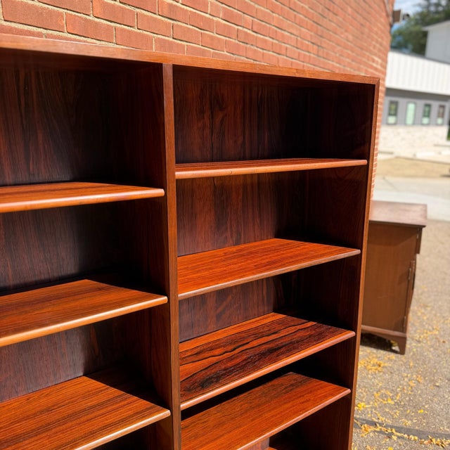 1960s Danish Modern bookcase in rosewood with two open shelving sections and a central divider. Each side has adjustable...