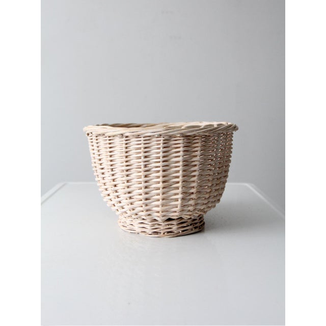 This vintage cream wicker basket features a warm woven texture and a softly rounded shape, making it a versatile storage...