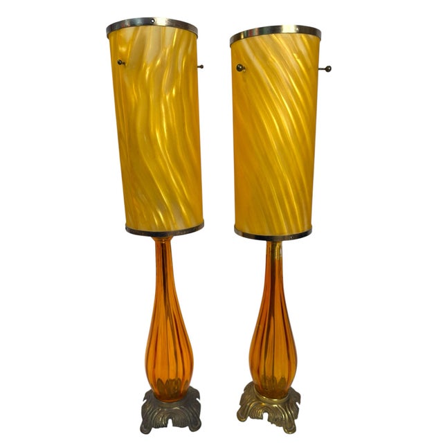 Exceptional pair of vintage sculptural table lamps featuring elongated amber/orange glass bodies with beautiful...