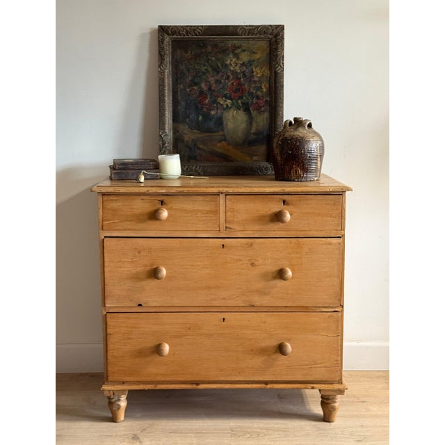 A honey pine chest of two short drawers over two long, fitted with turned wood knobs and small keyhole escutcheons, raised...