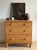 A honey pine chest of two short drawers over two long, fitted with turned wood knobs and small keyhole escutcheons, raised...