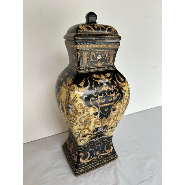 Elegant, decorative tall lidded vessel or urn. Black and gold renaissance revival artistry featuring cherubini, coat of...