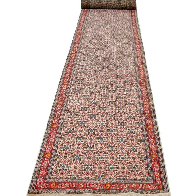 Handwoven 3x23 Old Persian Tabriz Runner featuring a beautiful all-over Herati design on an ivory-colored field enclosed...